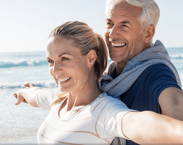 Happy middle aged couple enjoying a day at a beach