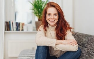 smiling red haired woman relaxing on her couch