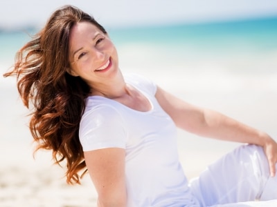 Fotolia_82357401_Subscription_Monthly_M-e1510613593986 Brown haired woman enjoys the breeze at the beach