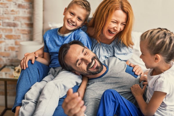 Happy family lying down on bed at home Happy family lying down on bed at home