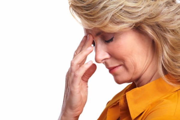 Senior woman having stress. Middle aged woman placing hand on forehead with a headache