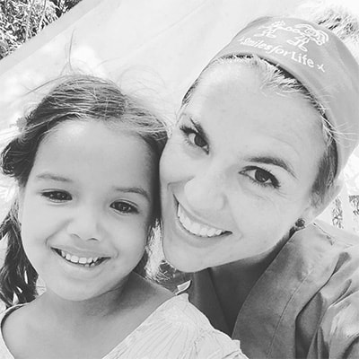 A team member of Dr. Rice smiling with a young dental patient