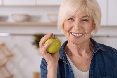 Senior woman enjoying a tasty green apple