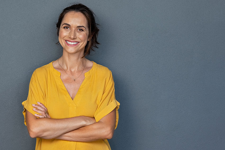 Woman smiling leaning against wall